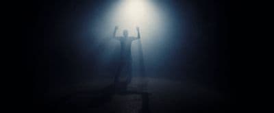 a person standing under a light in the dark