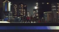 a group of people walking down a street at night