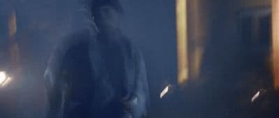 a blurry image of a man walking in a dark room