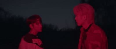 two men standing next to each other in the dark