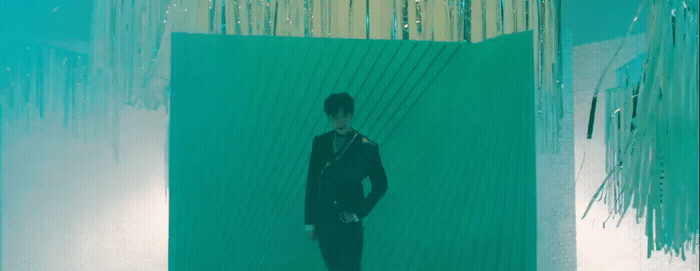 a man standing in front of a green wall