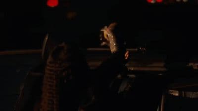a person holding a skateboard in the dark