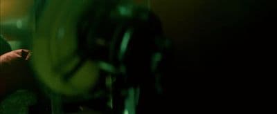 a man in a green shirt is looking at his cell phone