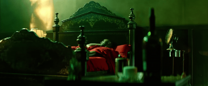 a man laying on a bed in a dark room