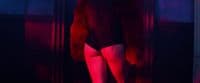 a woman standing in a dark room with a red light