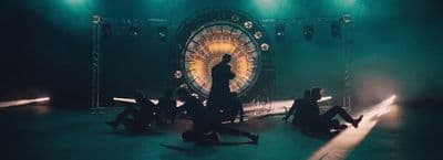 a group of people sitting on the ground in front of a stage