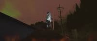 a man standing on top of a roof next to a fire