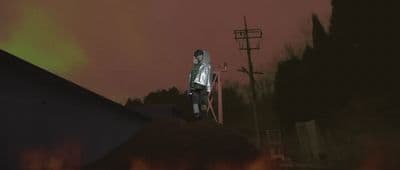 a man standing on top of a roof next to a fire