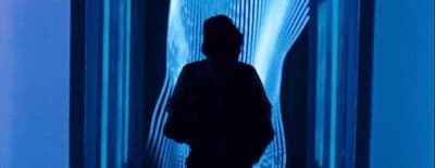 a man standing in front of a blue wall