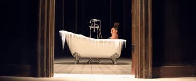 a woman sitting in a bathtub with icicles on it