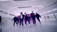 a group of young men dancing in a large room