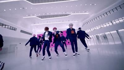 a group of young men dancing in a large room