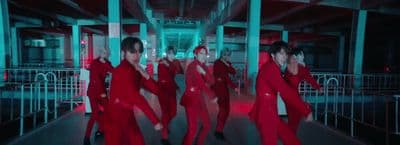 a group of people in red outfits dancing on a stage