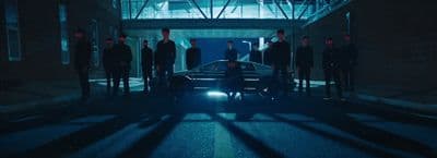 a group of people standing around a car