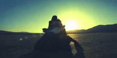 a person riding a motorcycle in the middle of a desert