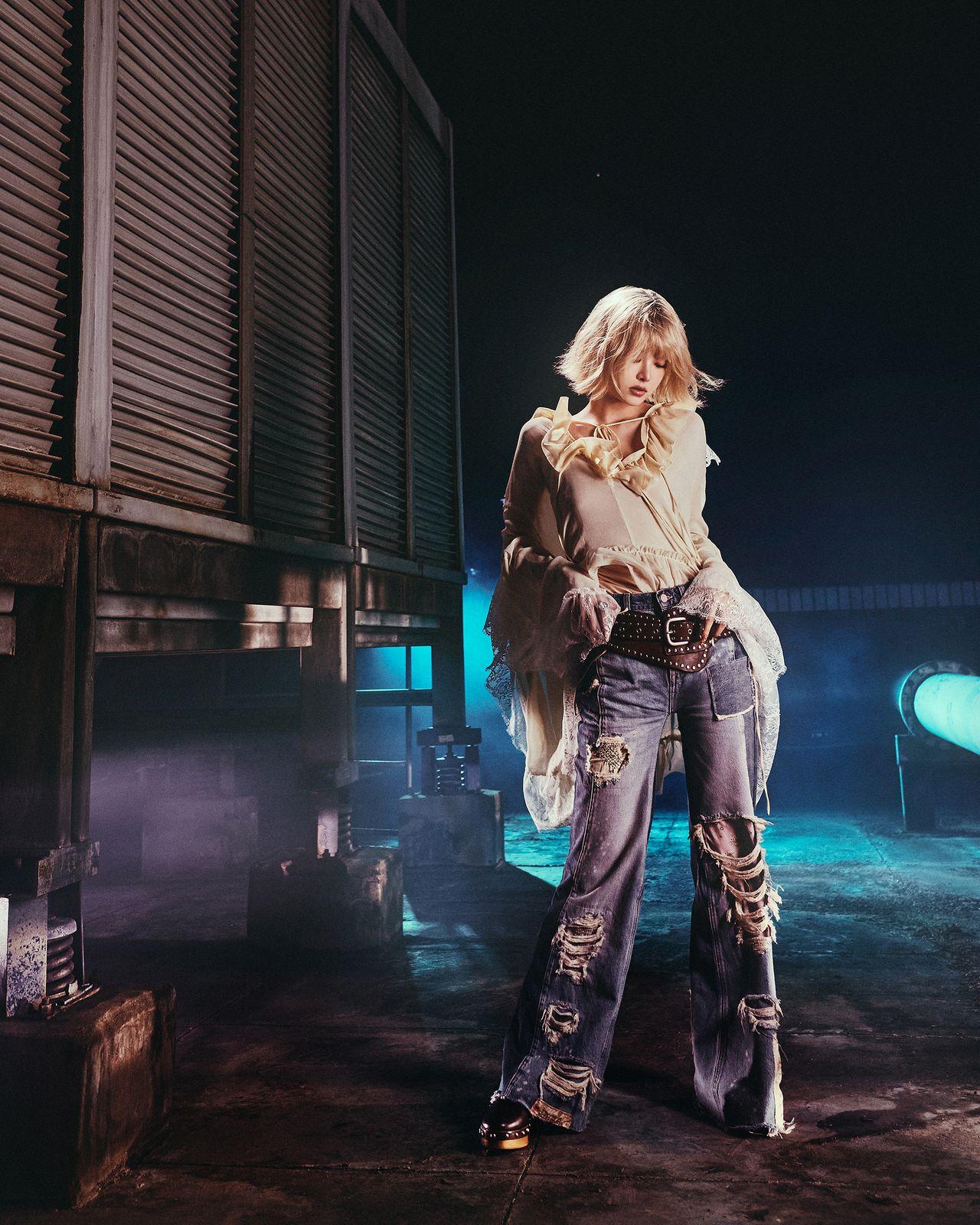a woman standing in front of a train at night