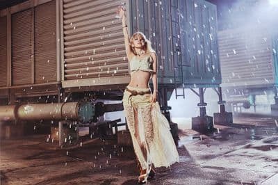 a woman is standing in front of a train