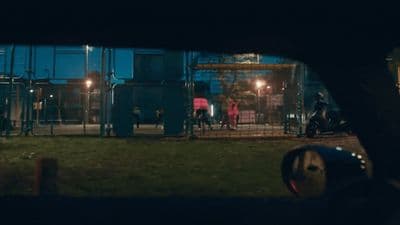 a group of people standing outside of a building at night