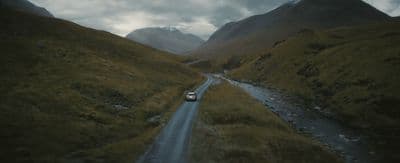 a car driving down a road in the mountains
