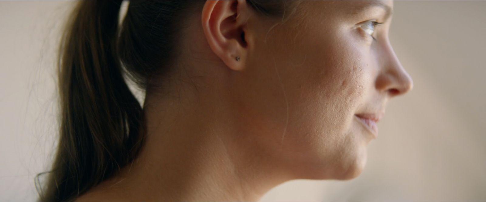 a close up of a woman's face and ear