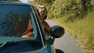 a woman leaning out the window of a car