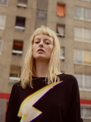 a woman standing in front of a tall building