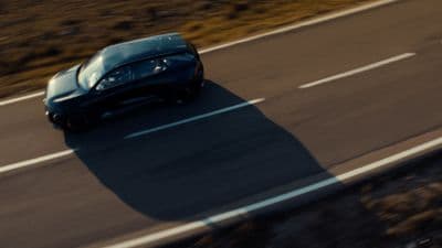 a black sports car driving down a road