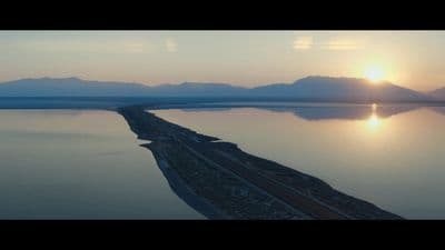 a large body of water with mountains in the background