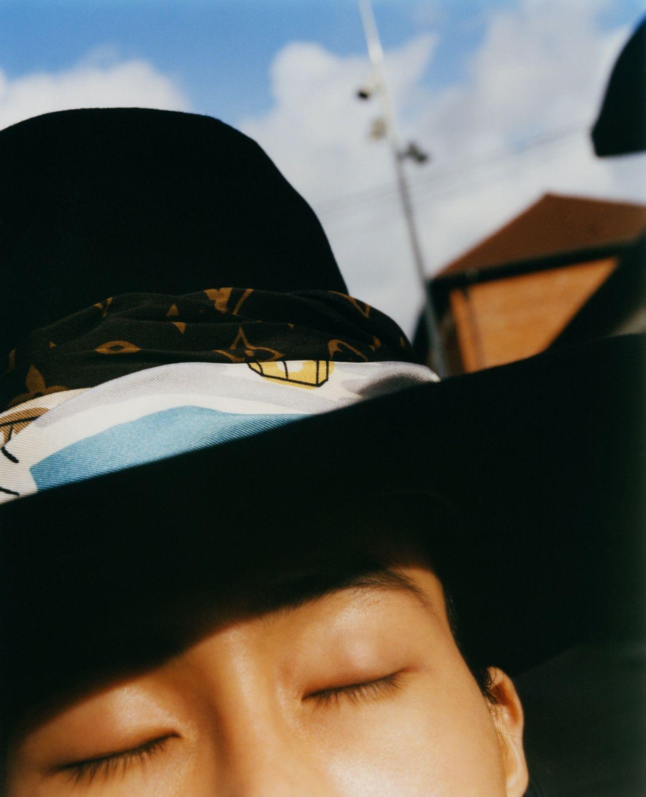 a man wearing a hat with his eyes closed