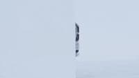 a man riding a snowboard down a snow covered slope
