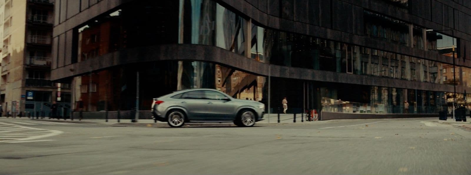 a car is parked in front of a tall building