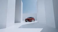 a red car is parked in a white room