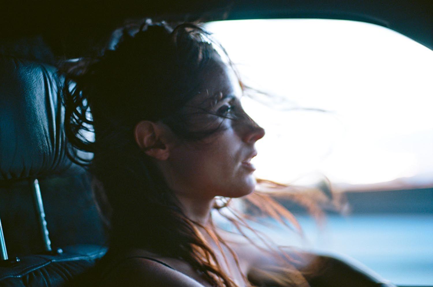 a woman sitting in a car looking out the window