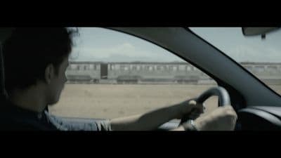 a man driving a car on a dirt road