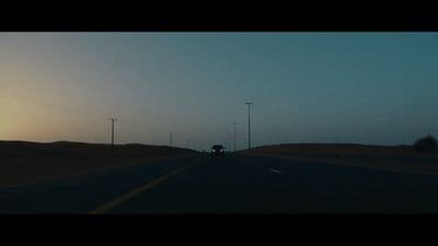 a car driving down a road at sunset