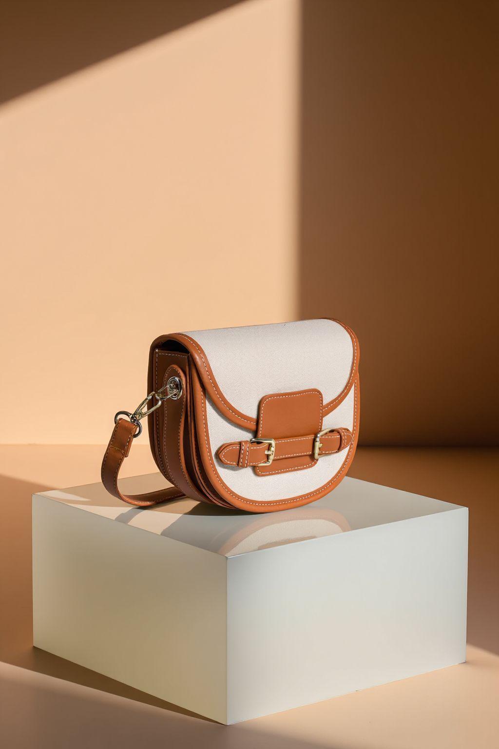 a white and brown purse sitting on top of a white box