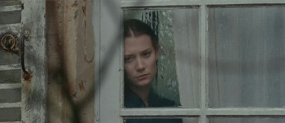 a woman looking out of a window in a house