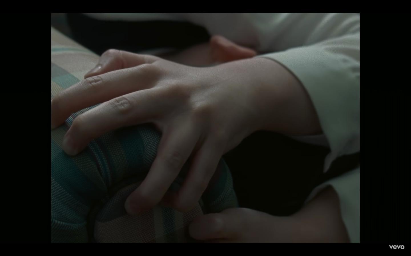 a person with their hands on a pillow