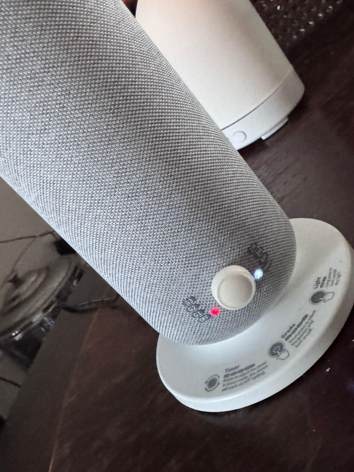 a white speaker sitting on top of a wooden table