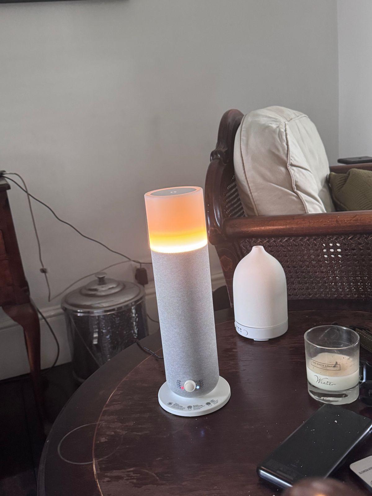 a table with a cell phone and a lamp on it