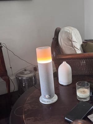 a table with a cell phone and a lamp on it