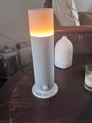 a table with a lamp and a cell phone on it