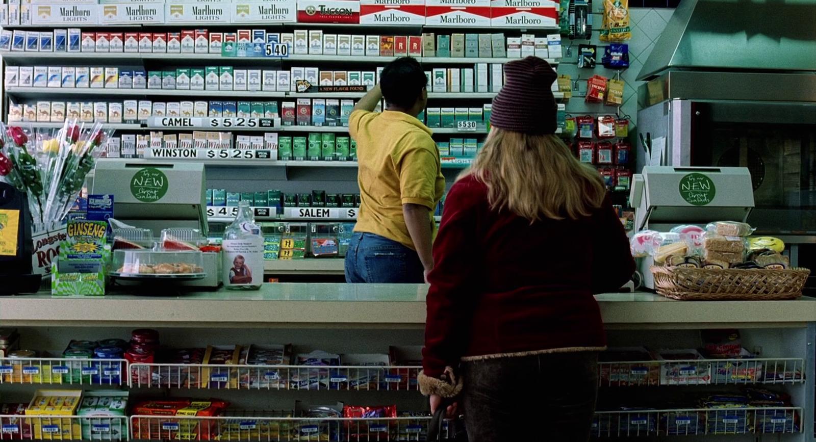 a man and a woman standing at a counter in a grocery store