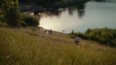 a person standing on a hill near a body of water
