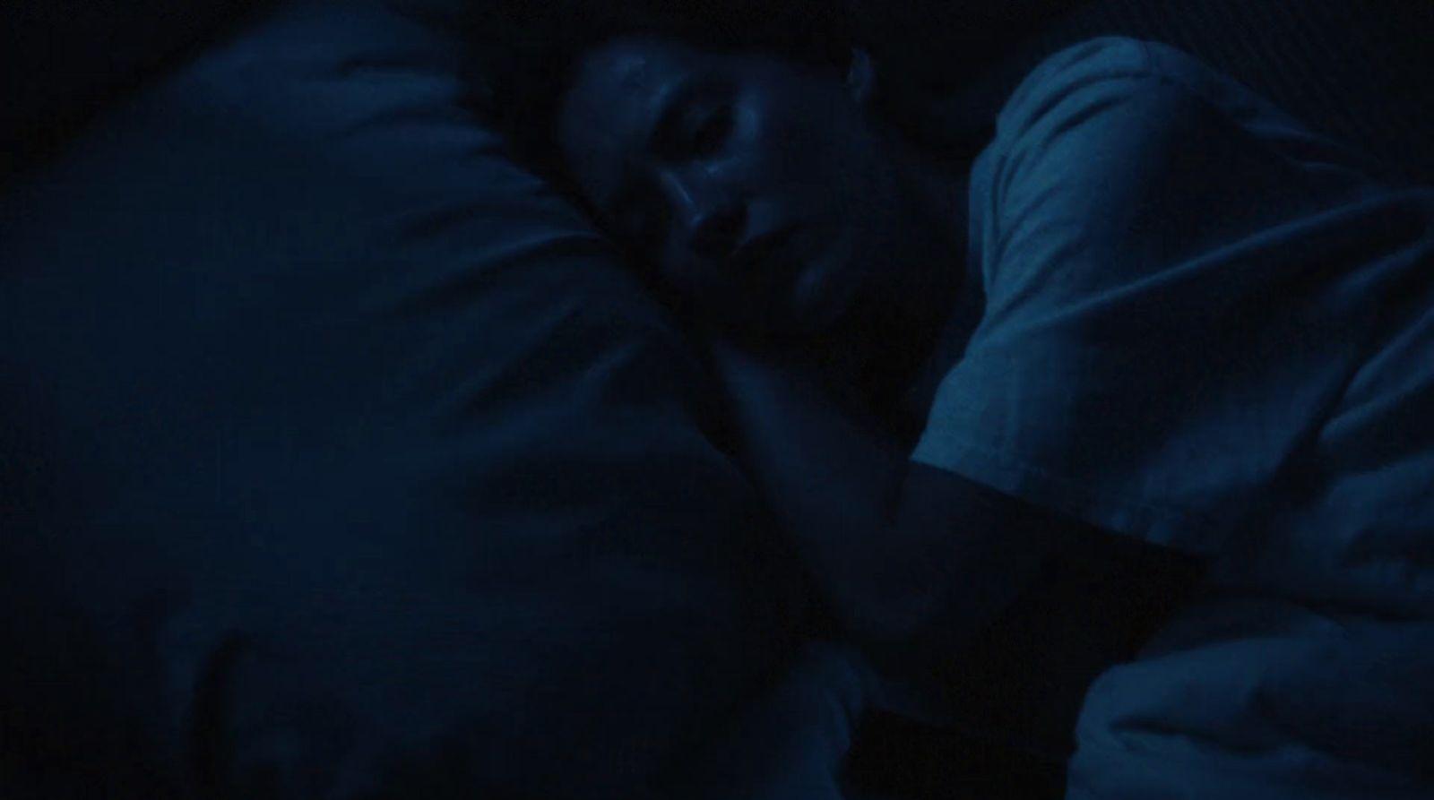 a person sleeping in a bed in the dark
