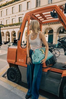 a woman standing next to a small orange truck
