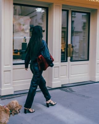 a woman walking her dog down the street