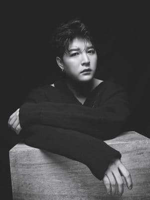 a black and white photo of a person leaning on a table