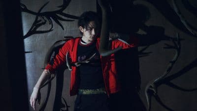 a person standing in front of a wall with a snake on it