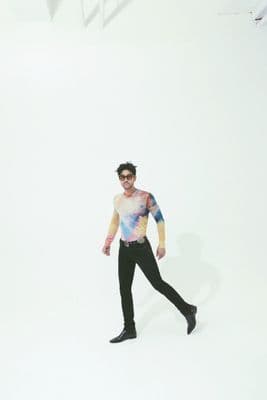 a man in a tie dye shirt and black pants